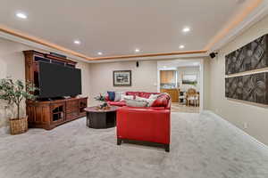 Living room with carpet floors and a tray ceiling