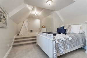 Bedroom featuring carpet and lofted ceiling