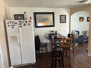 Dining room featuring dark wood-type flooring and a textured ceiling