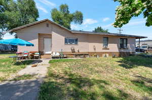 Rear view of house featuring a lawn