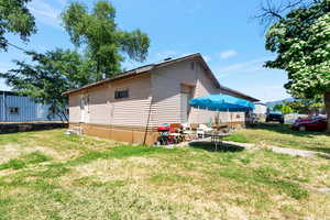 View of side of home featuring a patio and a yard