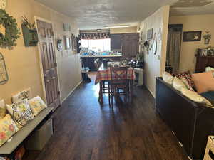 Dining space with dark hardwood / wood-style flooring and a textured ceiling