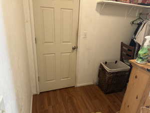 Laundry area with wood-type flooring