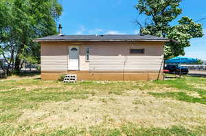 Back of house with a lawn