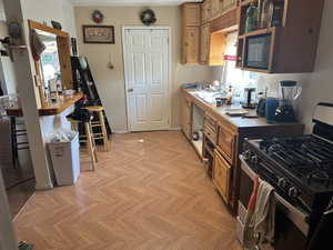 Kitchen on Building #2 downstairs featuring light parquet flooring and stainless steel range with gas cooktop