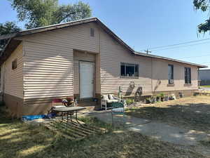 Back of property with a lawn and a patio area