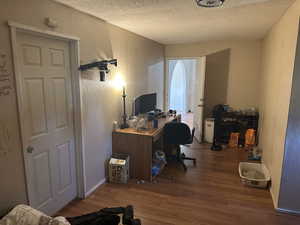 Office with a textured ceiling and wood-type flooring