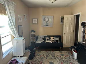 Master Bedroom of the Old House building #1. Interior space with a textured ceiling and dark hardwood / wood-style floors