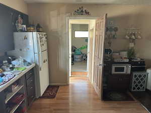 Kitchen with white appliances and light hardwood / wood-style flooring