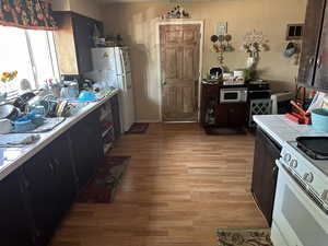 The kitchen at the Old House building #1 with white appliances, tile countertops, and light hardwood / wood-style flooring