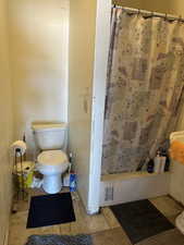 Bathroom #1  with toilet and a shower with curtain at