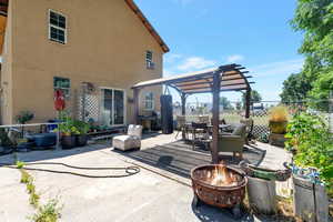 View of patio featuring a pergola, an outdoor fire pit, and a deck