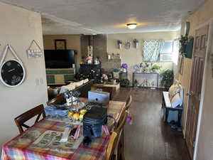 Dining area with a textured ceiling and hardwood / wood-style floors