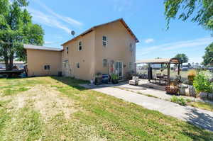 Rear view of house featuring a patio area, a fire pit, and a yard