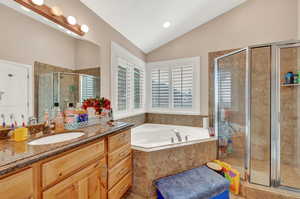 Bathroom featuring lofted ceiling, independent shower and bath, and vanity