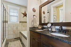 Master Bathroom featuring dual bowl vanity, tile flooring, and walk-in shower