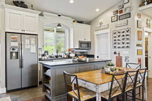 Kitchen with white cabinets, stainless steel appliances, sink, and kitchen island.