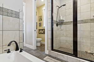 Master Bathroom with tile flooring, walk-in shower, and toilet room