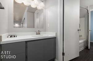 Bathroom featuring bathtub / shower combination, vanity, and hardwood / wood-style floors