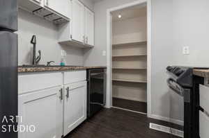 Kitchen with electric range oven, white cabinets, dark wood-type flooring, and fridge