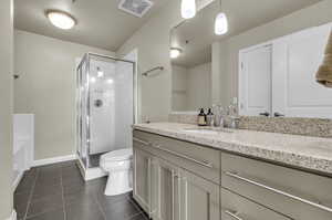 Full bathroom with plus walk in shower, vanity, tile floors, and toilet