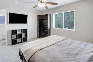 Bedroom featuring ensuite bath, ceiling fan, and carpet