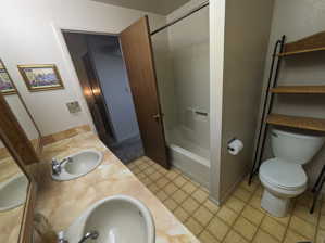 Full bathroom featuring tile flooring, bathing tub / shower combination, toilet, and dual bowl vanity