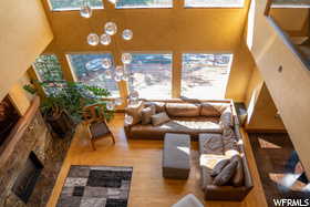 Living room featuring an inviting chandelier, a towering ceiling, hardwood / wood-style floors, and a fireplace