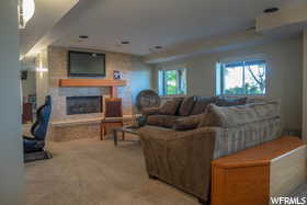 Living room with a stone fireplace and carpet floors