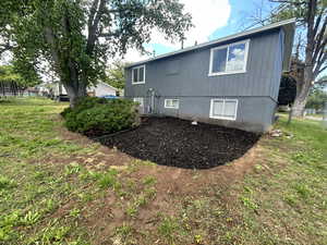 Rear view of property featuring central AC and a yard