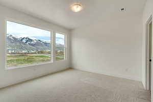 Spare room featuring a mountain view and carpet floors