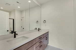 Bathroom featuring oversized vanity, dual sinks, and tile floors