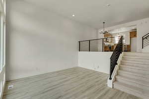 Interior space featuring an inviting chandelier, a high ceiling, and light hardwood / wood-style flooring