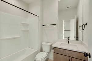 Full bathroom featuring bathing tub / shower combination, toilet, and vanity