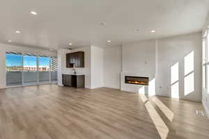 Upper floor unfurnished living room with light hardwood / wood-style flooring and sink