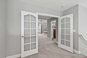 Hall with light carpet and french doors