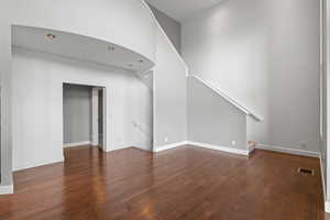 Unfurnished living room with dark wood-type flooring