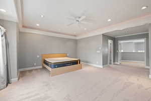 Unfurnished bedroom with ceiling fan, crown molding, and light colored carpet