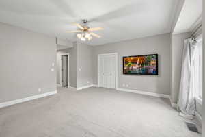 Carpeted empty room with ceiling fan