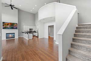 Stairway featuring a high ceiling, ceiling fan, hardwood / wood-style floors, and sink