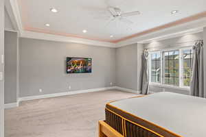 Carpeted bedroom with ornamental molding and ceiling fan