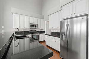 Kitchen featuring white cabinetry, stainless steel appliances, sink, and wood-type flooring