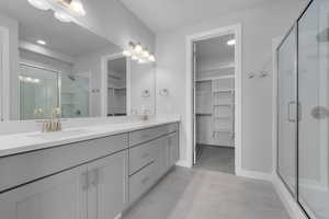 Bathroom featuring tile patterned flooring, an enclosed shower, and vanity