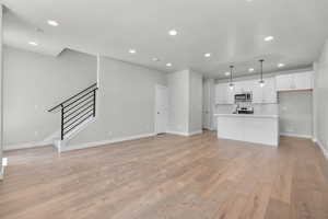 Unfurnished living room with light wood-type flooring and sink