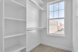 Spacious closet with light colored carpet