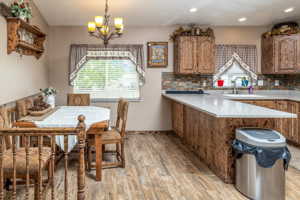 Kitchen with light hardwood / wood-style floors, sink, tasteful backsplash, and kitchen peninsula