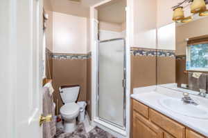 Bathroom with walk in shower, tile flooring, toilet, and large vanity