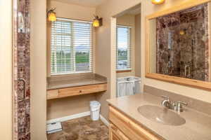 Bathroom featuring a shower with shower door, vanity with extensive cabinet space, and tile floors
