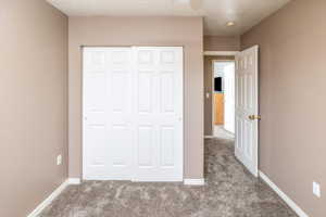 Unfurnished bedroom with a closet and carpet floors