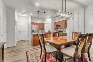 Dining space featuring a notable chandelier and light wood-type flooring